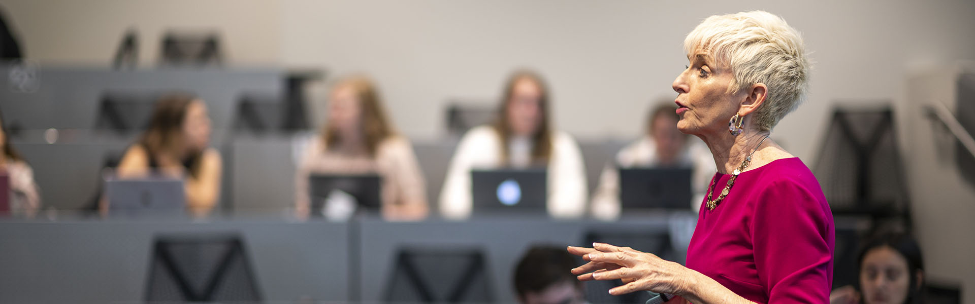 Female scheller faculty member lecturing in front of class