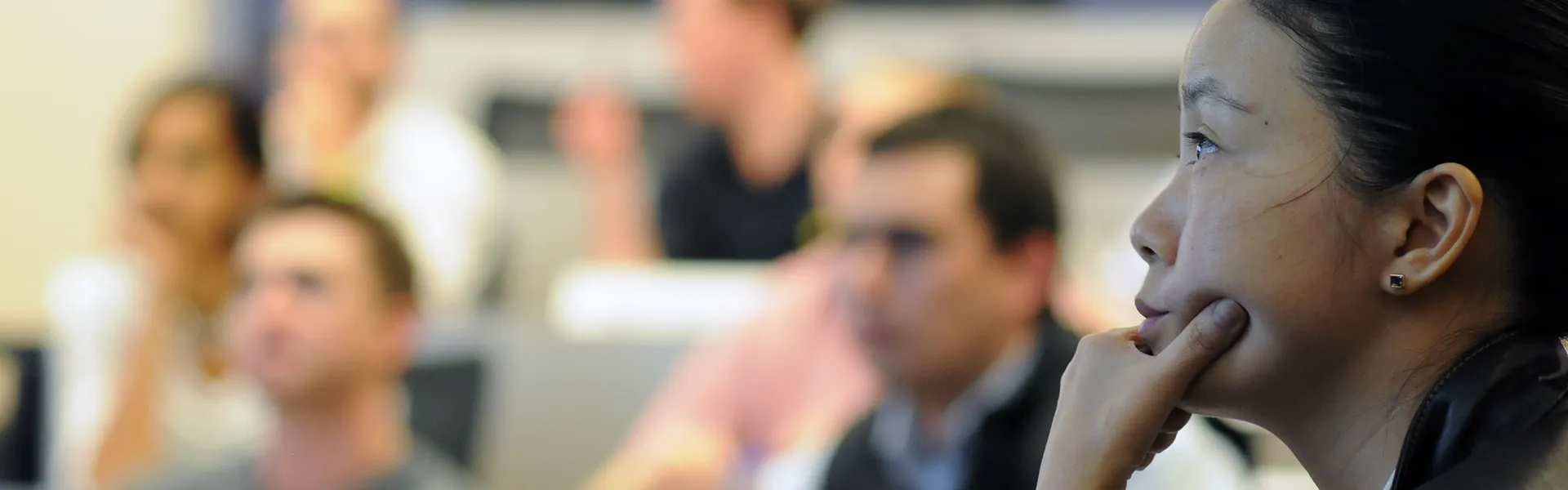 Student looking forward in class, resting chin on hand