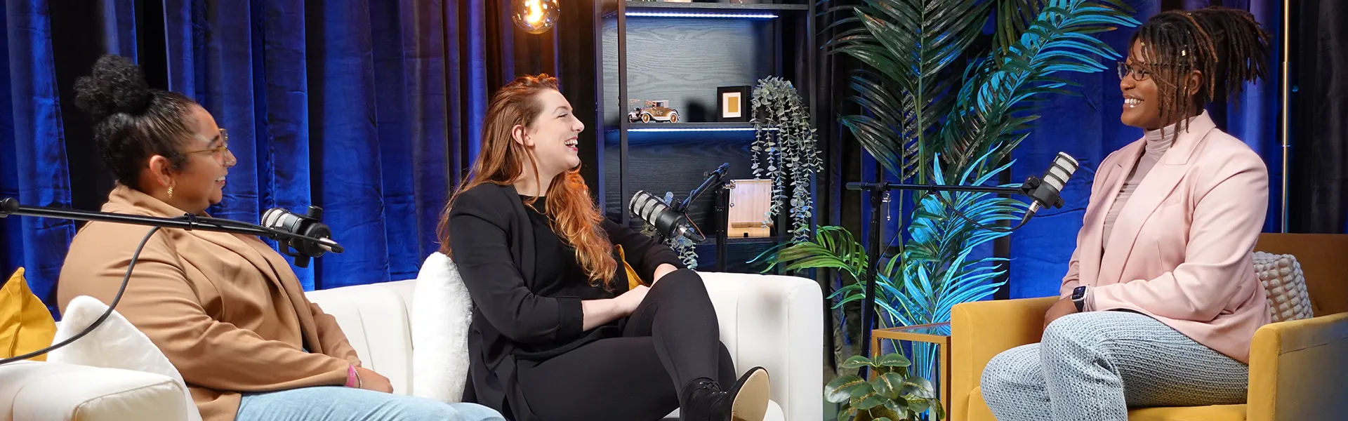 guests chatting on couch in podcast room