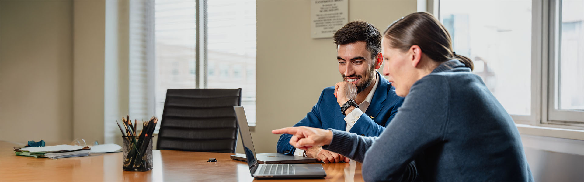 Student getting career advise from another, sitting at a business table