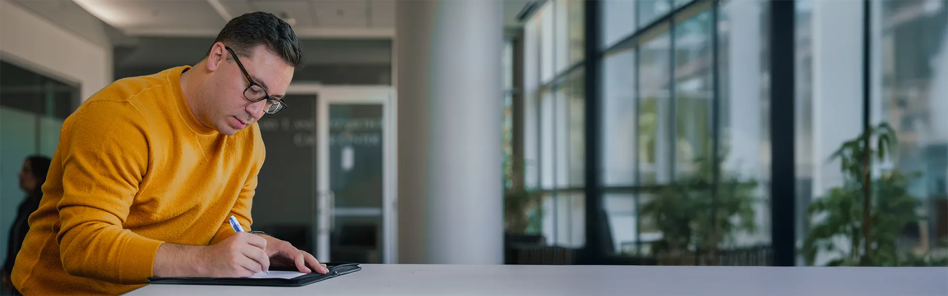 PhD Student reviewing paperwork on tall desk