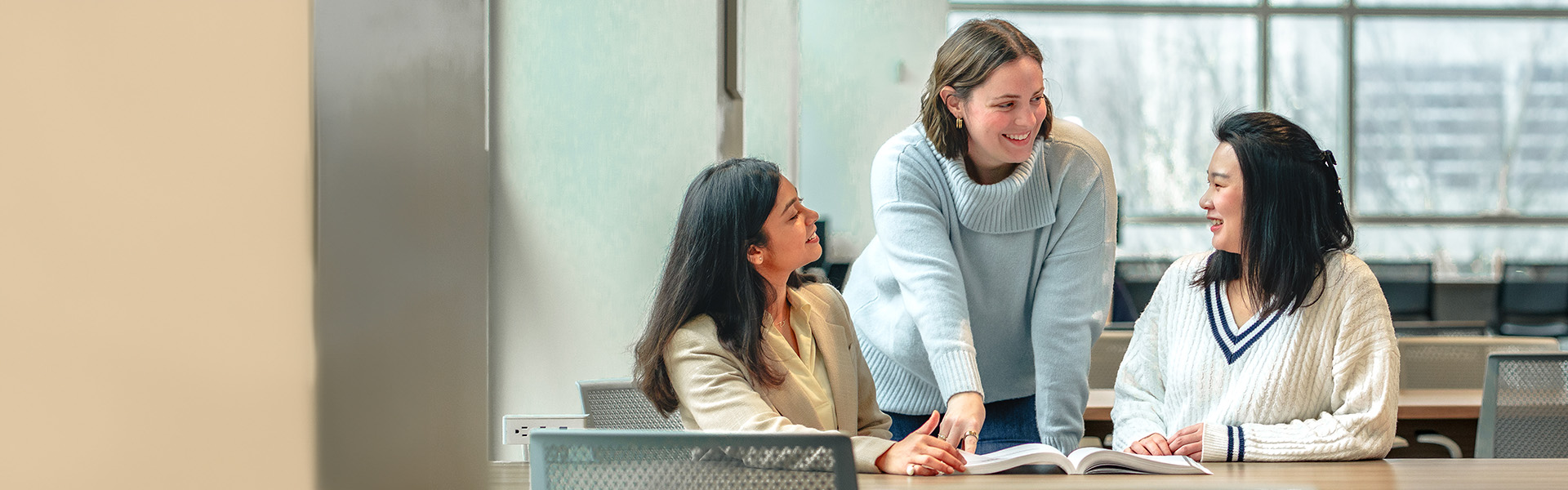 Three women work together in an office setting
