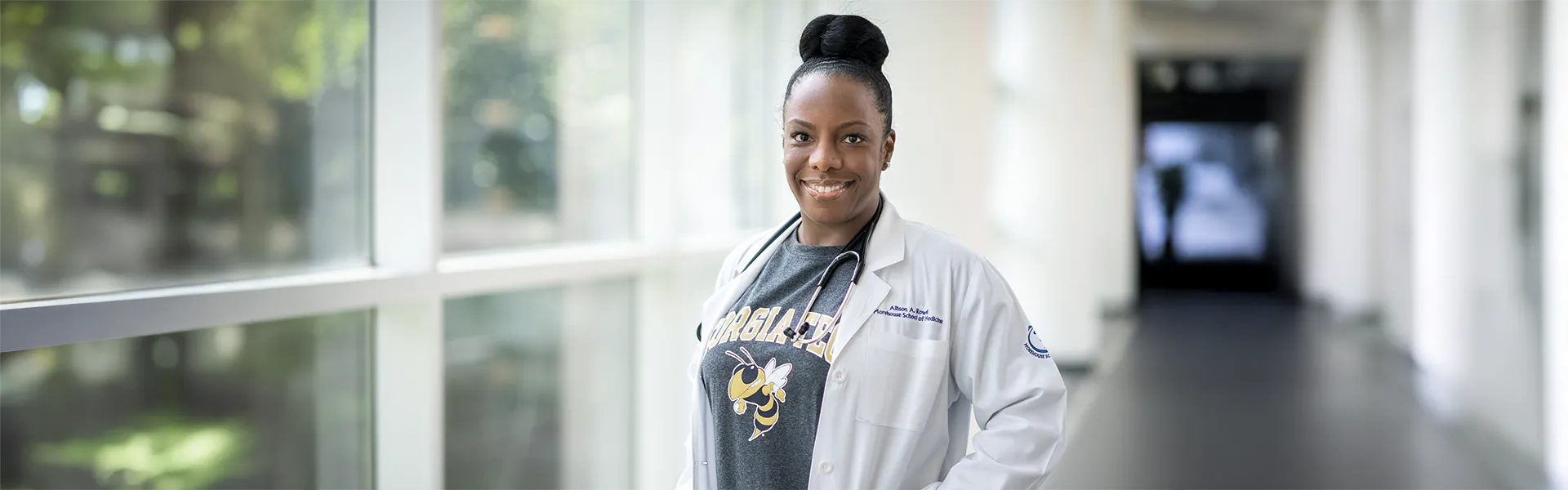 Dual md/mba student wearing a GT t-shirt under a doctors robe