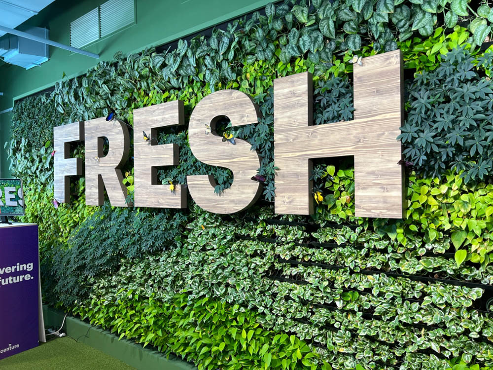 The living wall at Accenture's Atlanta Hub features the word 'Fresh' and mechanical butterflies