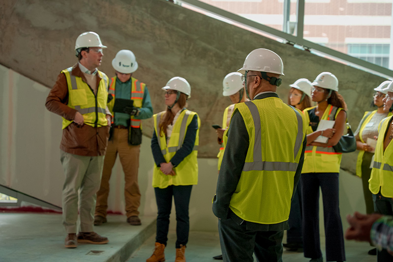 People pause on a tour of a building mid-construction