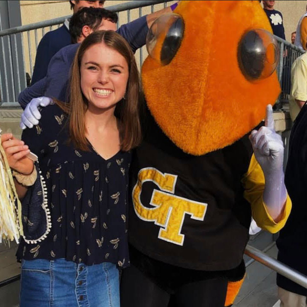 Undergraduate student with Scheller mascot Buzz