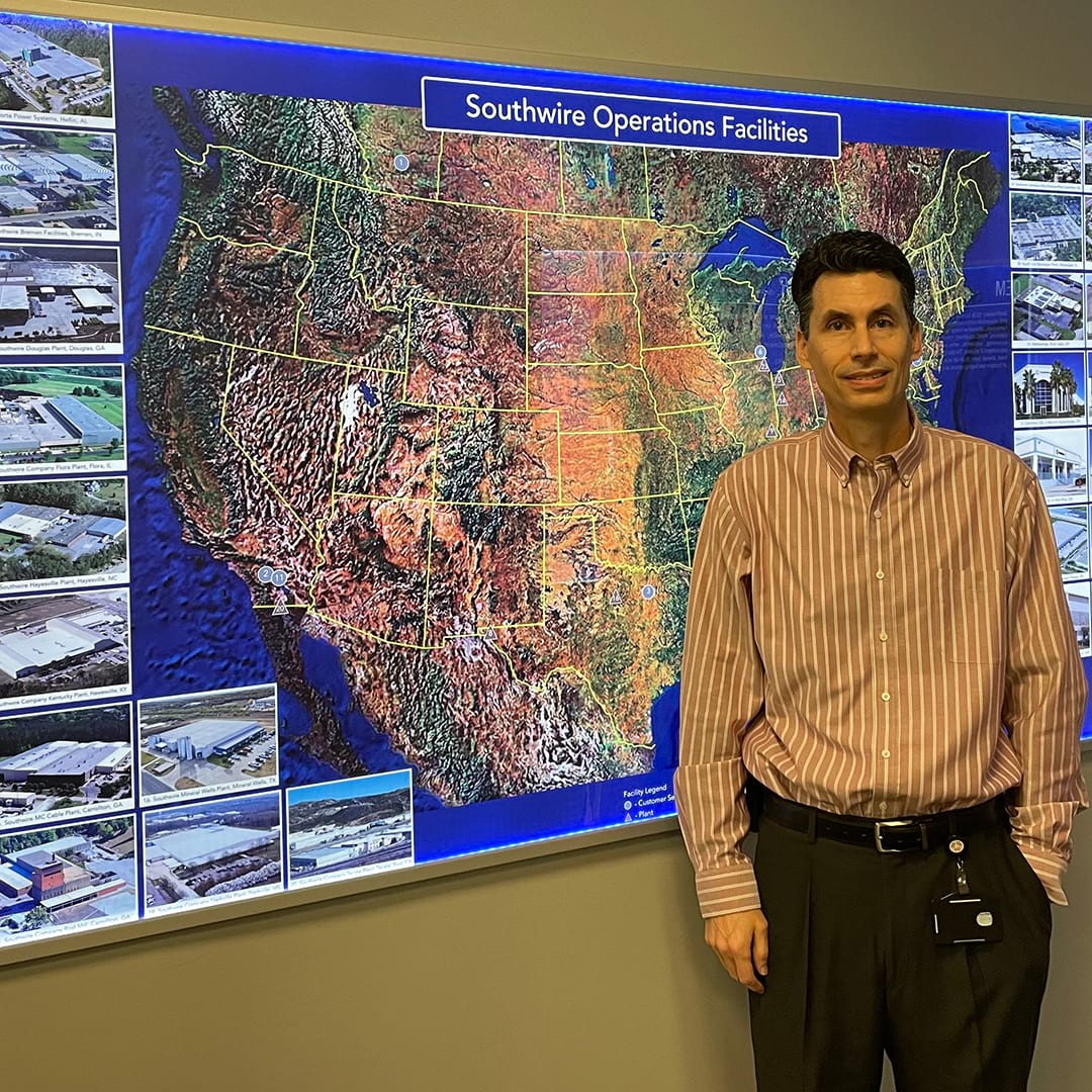 Bo Quick standing before a wall map of the United States