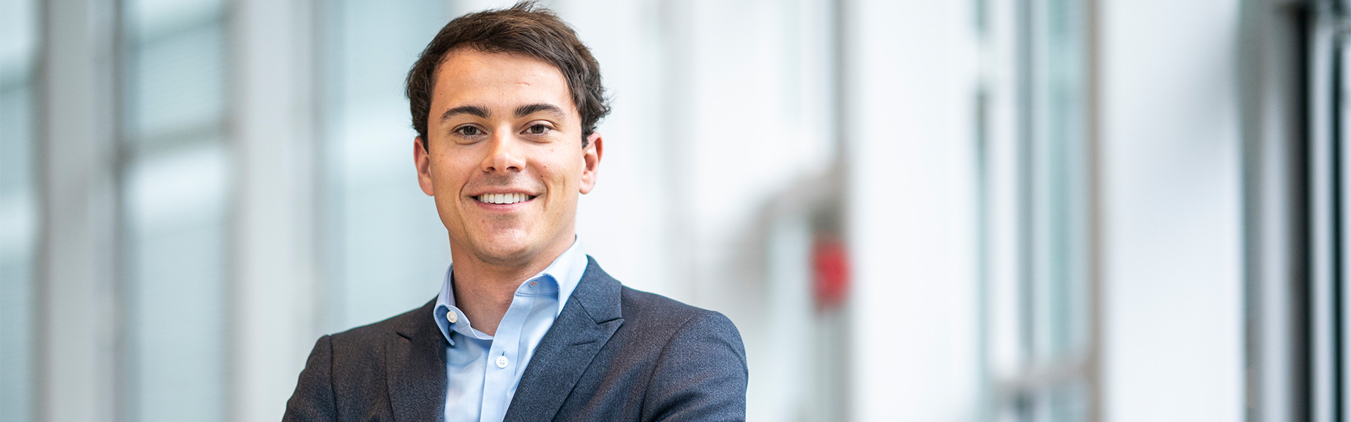 A small group of people gathered around a laptop in a conference room.
