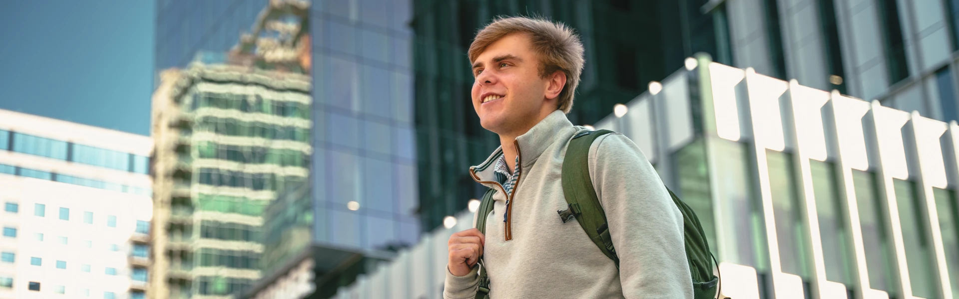 student with backpack stands in front of building in Atlanta