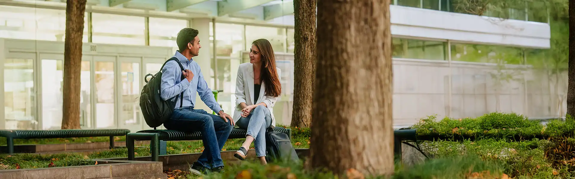Two students siting at the main entrance to the Scheller College of Business
