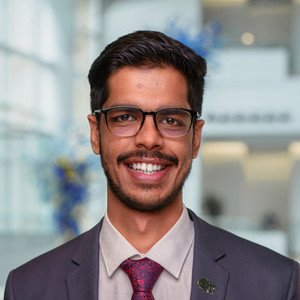 Shashwat Dev smiles in a suit jacket