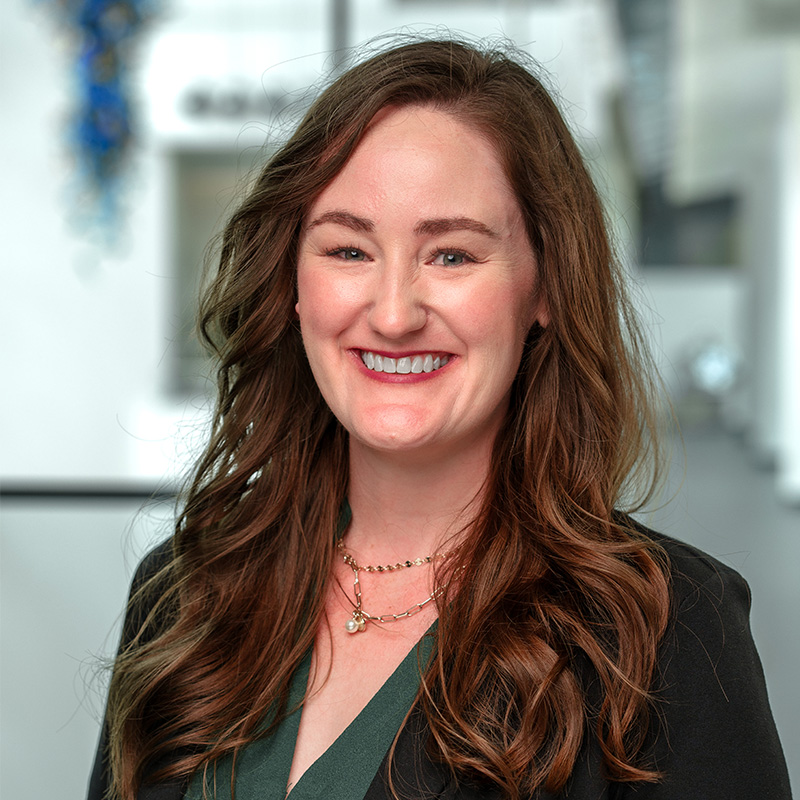 Kelsey Terreson smiles in a green suit jacket