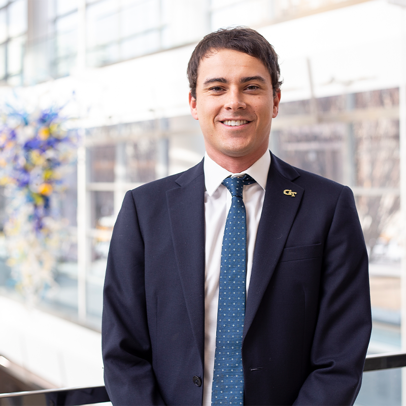 Leo Haigh, Full-time MBA '23, dressed in a suit and tie in the Scheller atrium