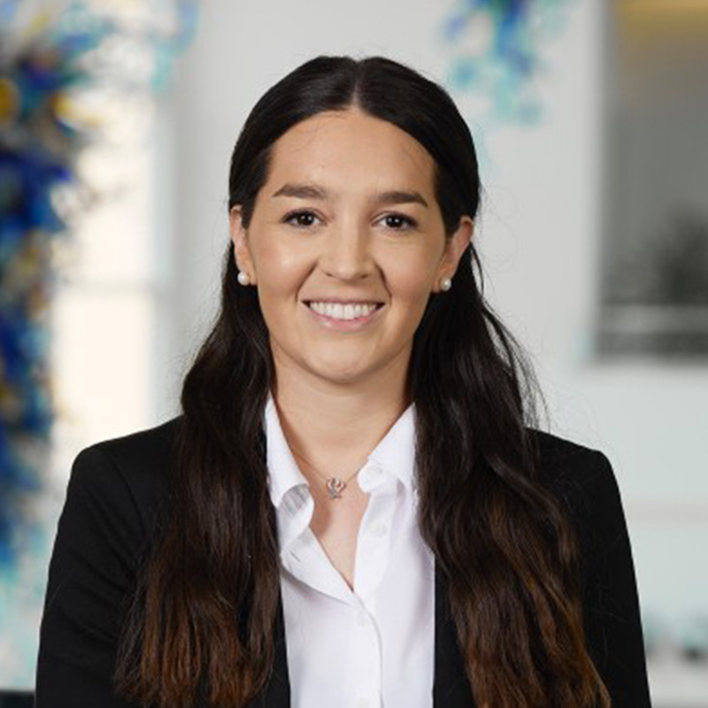 Nicole Muller smiles in a black suit jacket