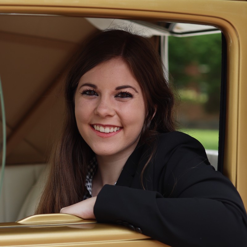 Lacey Shaffer, BSBA '22 poses in the Ramblin' Wreck