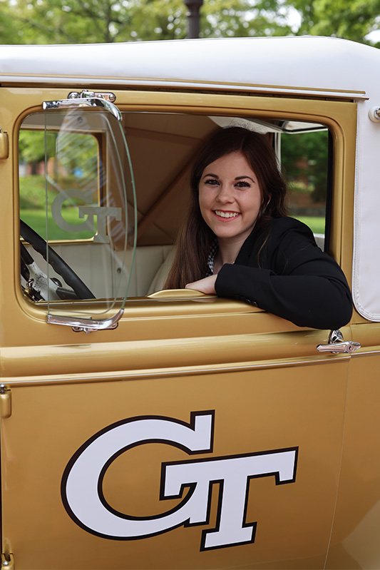 Lacey Shaffer, BSBA '22 poses in the Ramblin' Wreck
