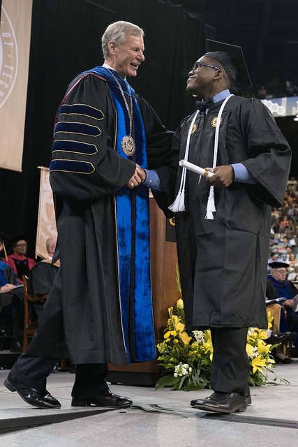 President Bud Peterson congratulates an undergraduate at the Saturday afternoon ceremony.