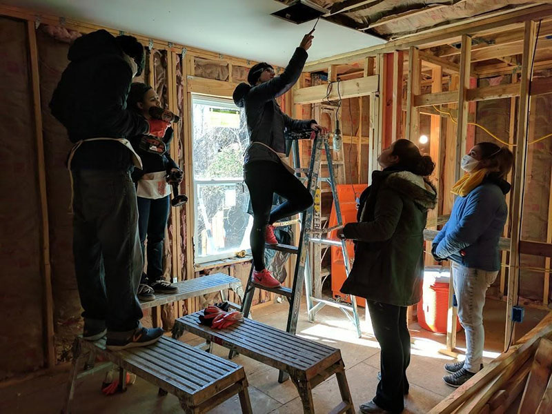 MBA students insulated a newly built home and installed ceiling, floor, and bathroom drywall