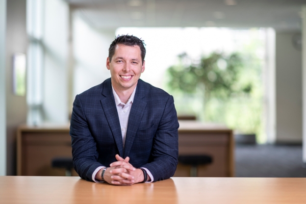 Christian White, an Executive MBA alumni, sits at a desk. 