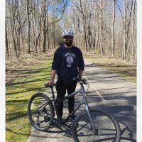 Full-time MBA student Akshay Verma stands next to his bike on a trail