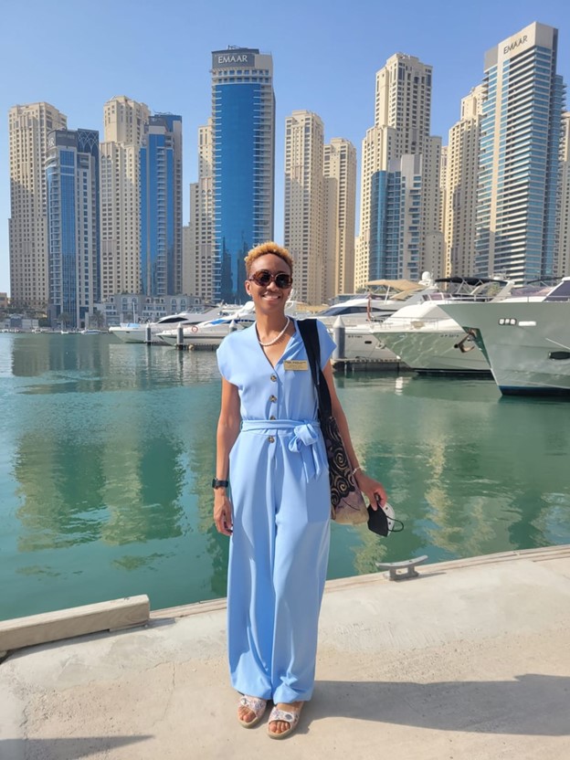 A student stands in Dubai with buildings behind them