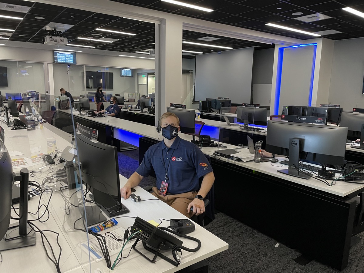 Full-time MBA alumnus Luke Walker sits at a computer in NASA's mission control.