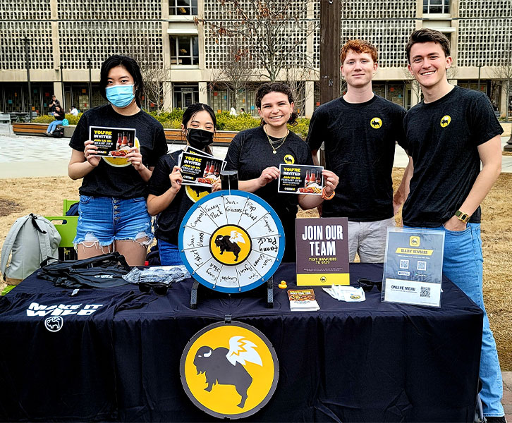 Scheller undergrads (from left to right) Annie Lin, Helen Nguyen, Abby Adams, Jack Deal, and William Leroy work at a Buffalo Wild Wings Go tabling event as part of their strategic marketing plan deployed during the Marketing Consulting Practicum course in Spring 2022. 