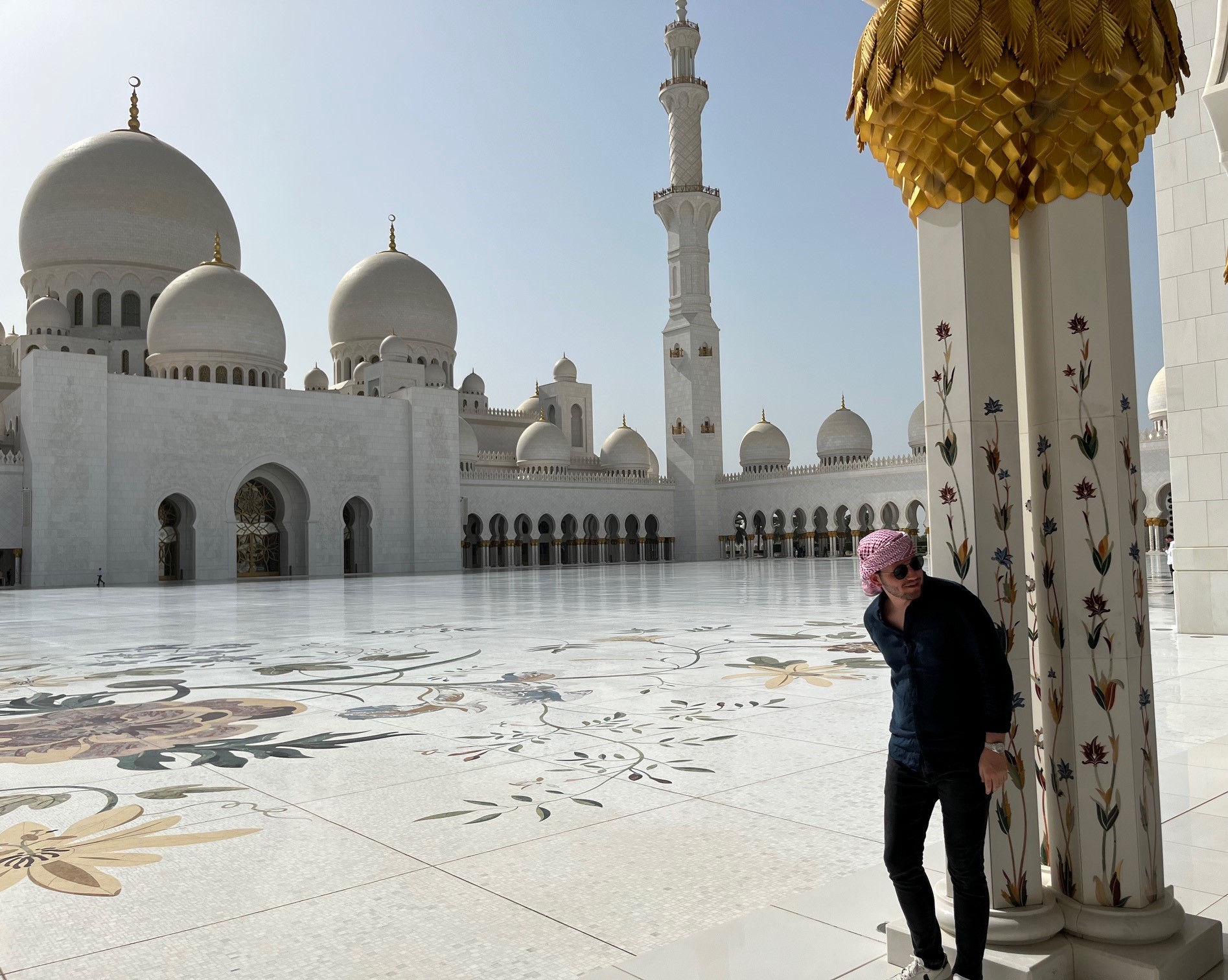 A man stands outside of a white building