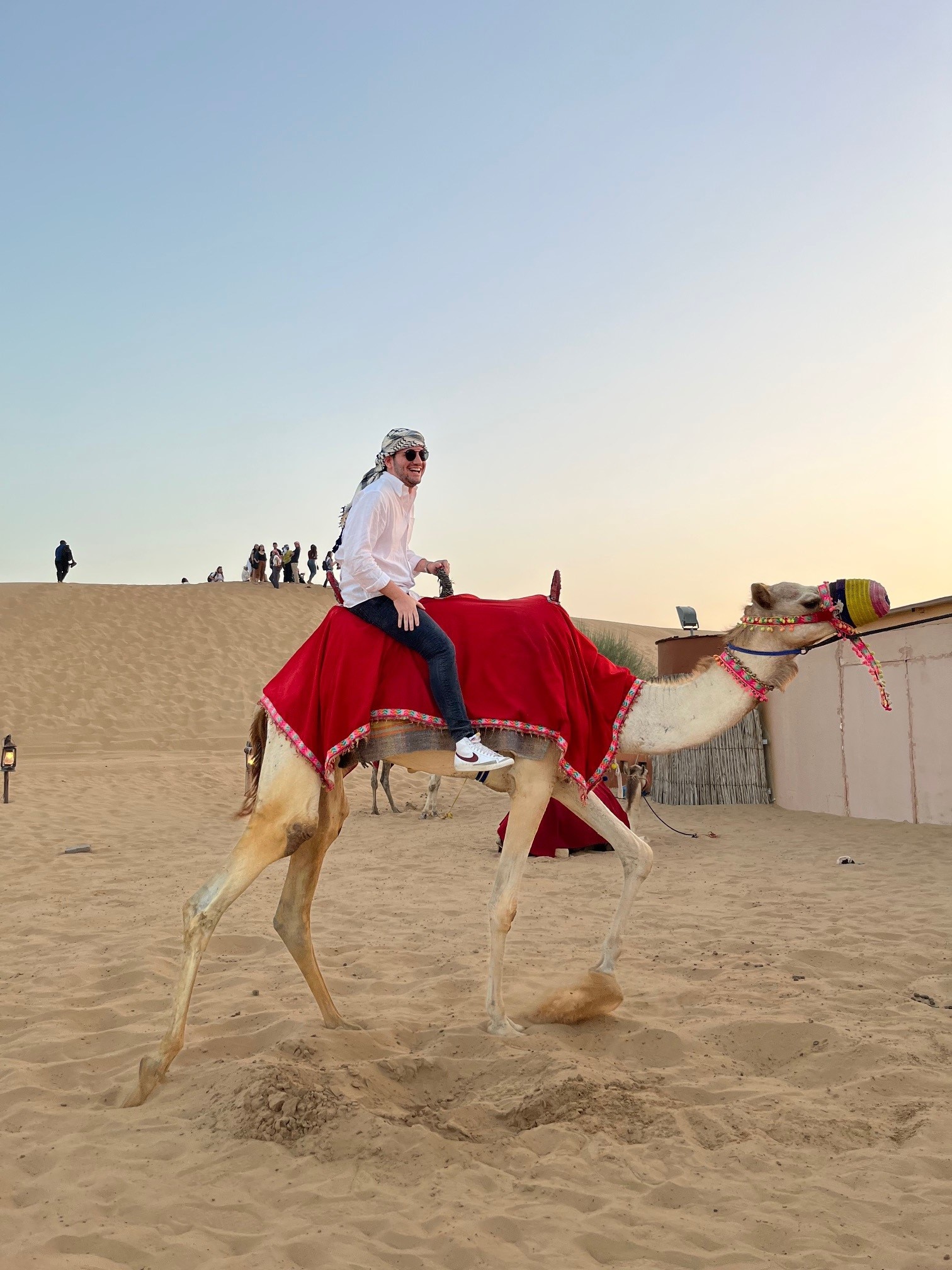 A man rides a camel in the desert