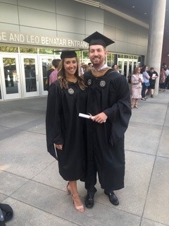 Two MBA graduates in graduation gowns