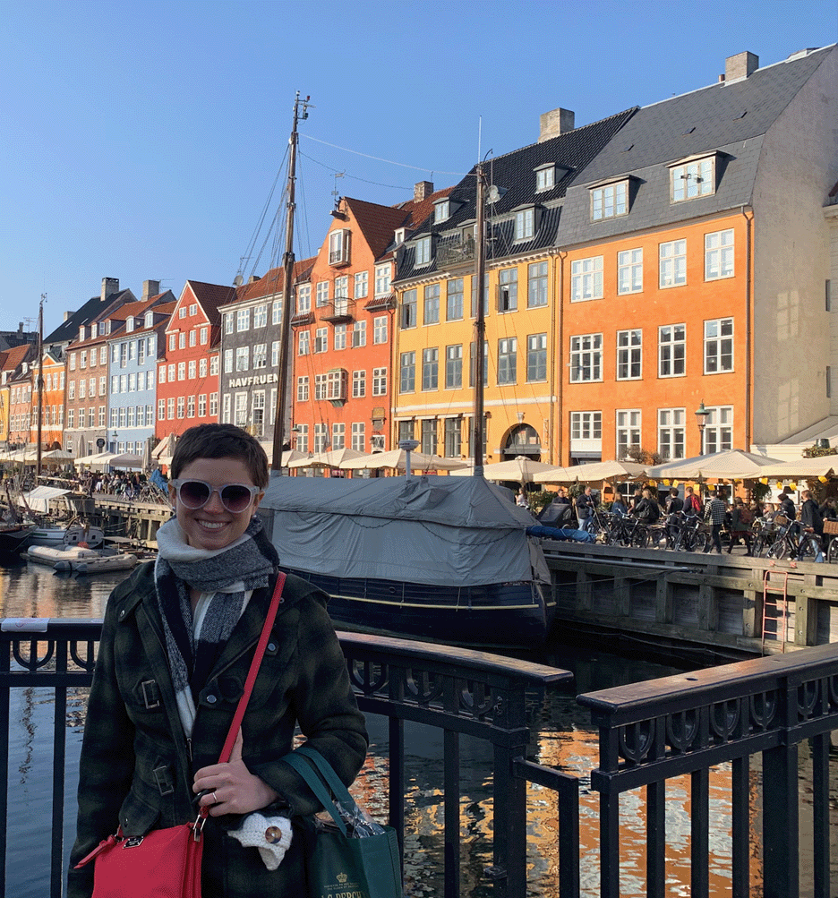 A female stands in front of a river in Denmark.