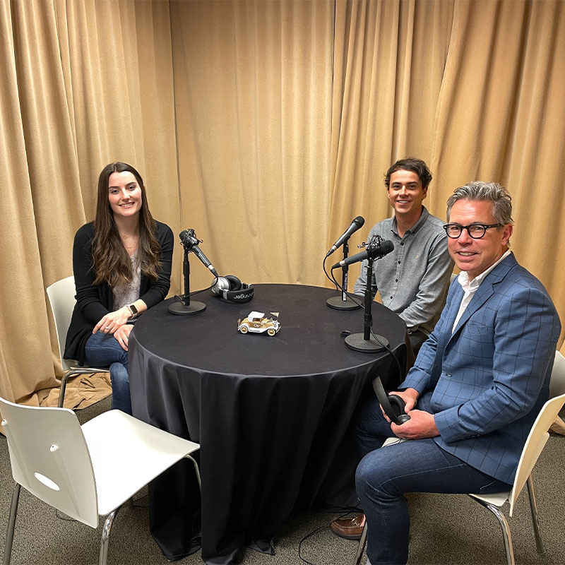 Kat Macchio, Trent Thurman, Leo Haigh sitting around podcast table.