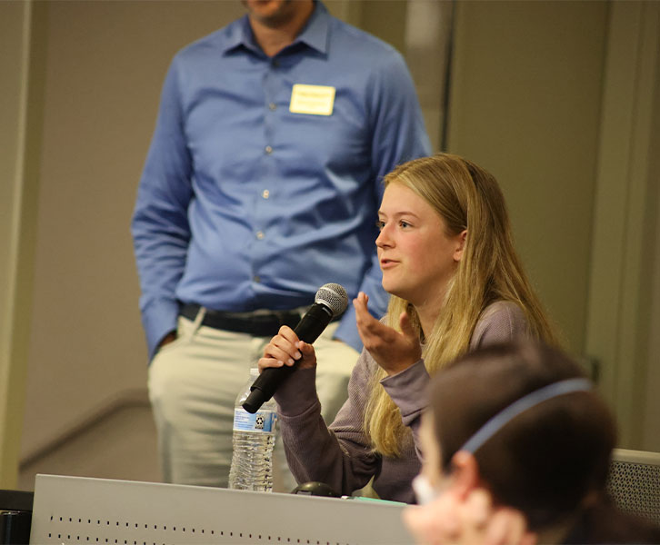 Scheller undergraduate student Charlotte Lawson poses a question to the speakers at the Scheller Marketing Insights Symposium, where students connected with industry leaders from Accenture, Kobayashi, NCR, Nebo, and Newell Brands. 