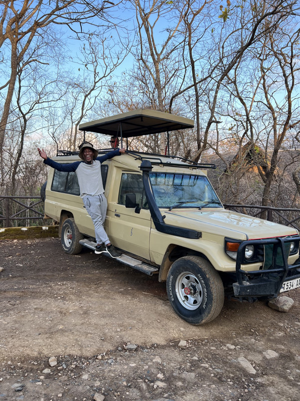 man posing in front of car