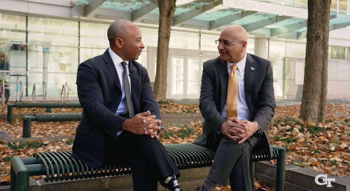 Dean Anuj Mehrotra and Raheem Beyah sitting on a bench outside 