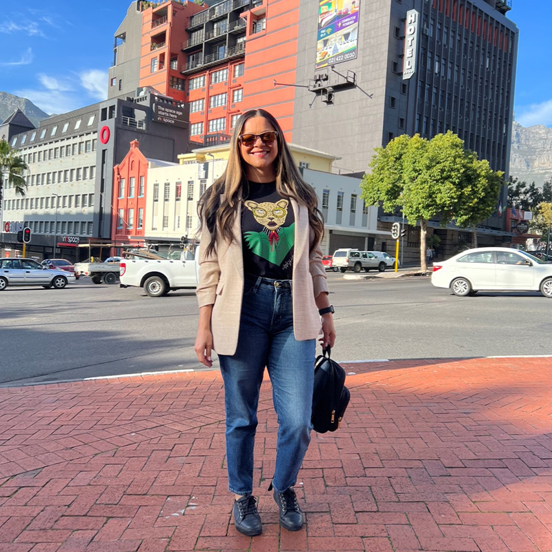 Maria Guzman, Executive MBA ’23, stands smiling on a red brick sidewalk in South Africa