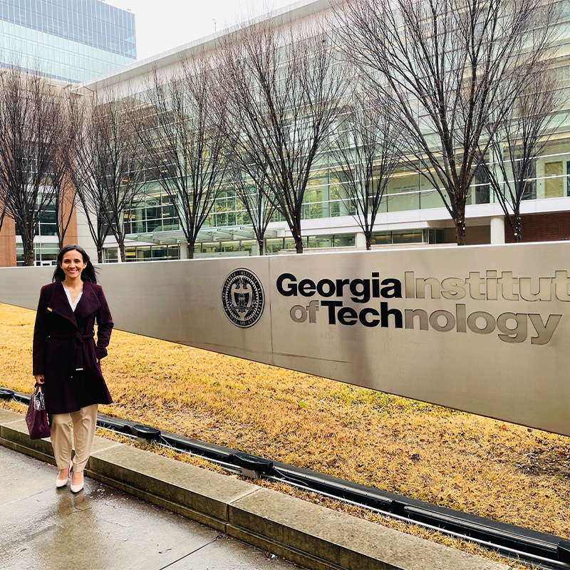 Fanny Baires Flores, Evening MBA ’23, stands outside the Scheller College of Business intersection on a rainy day 