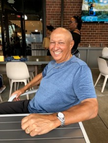 Haywood Solomon smiling sitting at a table outside