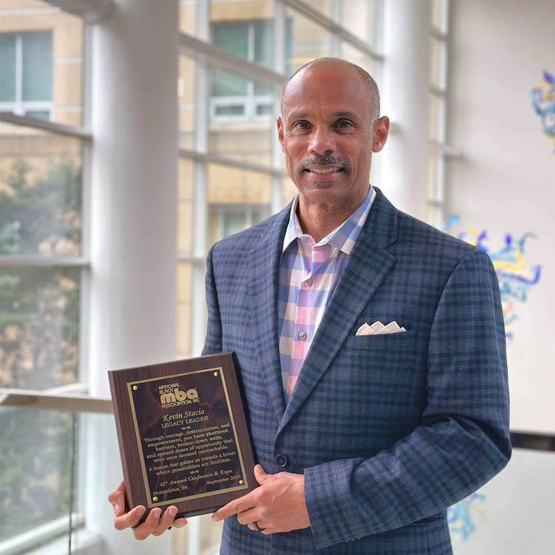 Kevin Stacia holding Legacy Leader Award from the National Black MBA Association