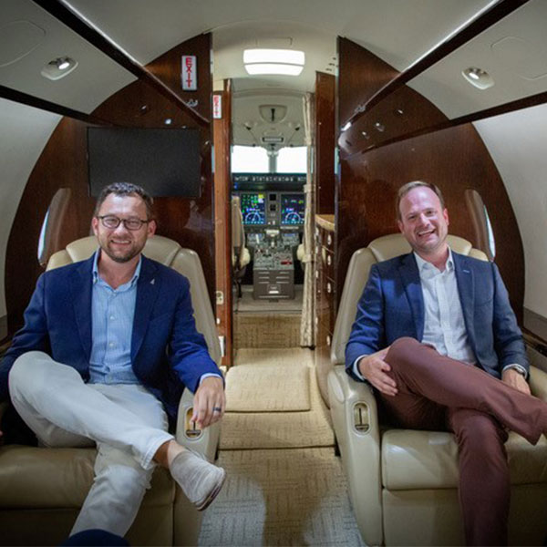 Jared Hasty and Sean Sanders, founder of Piedmont Jets, sitting in a private aircraft.