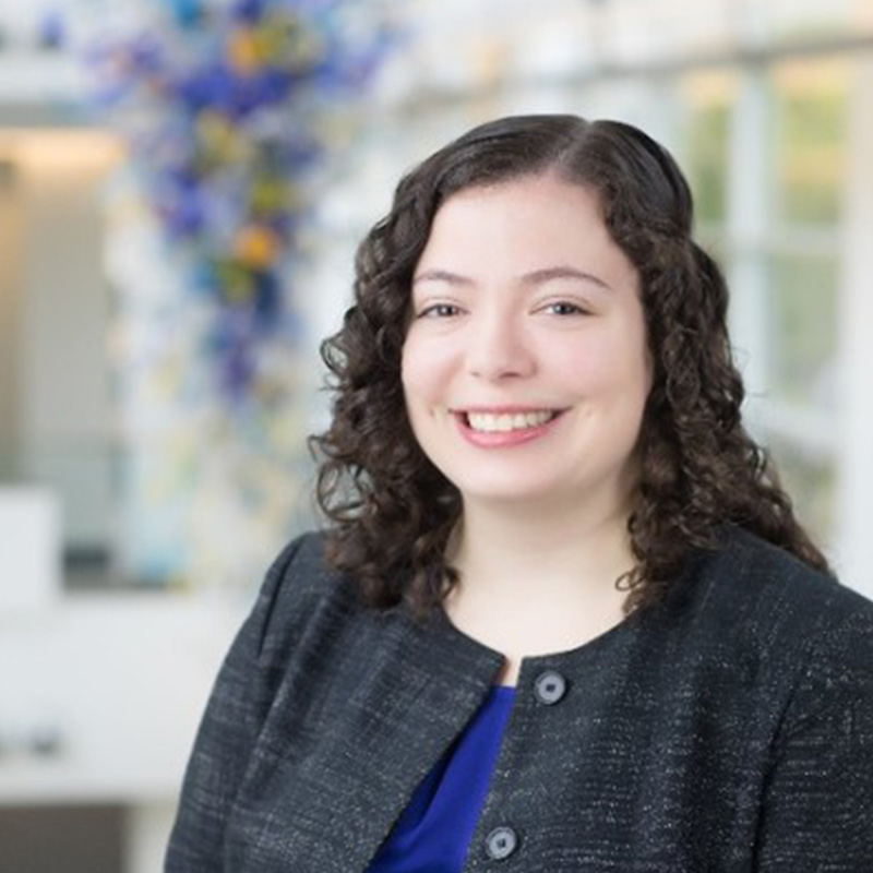 Full-time MBA alumna Rachel Wiseley, in a black jacket, smiles in the Scheller College of Business atrium