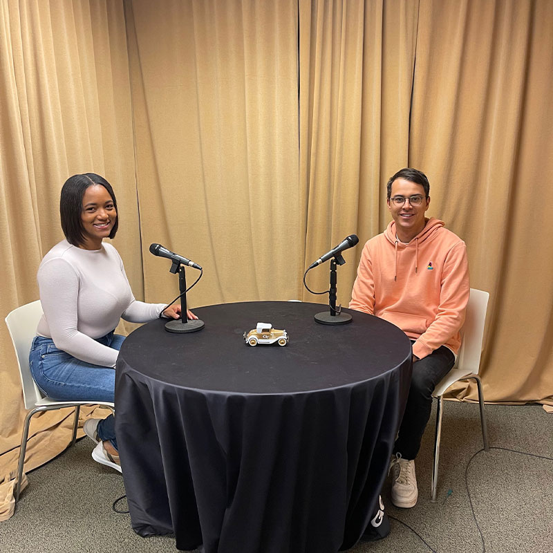 Full-time MBA student Leo Haigh and Stephanie Smith, BSBA ‘09 and founder of Social by Steph, sit around a table to record a podcast.