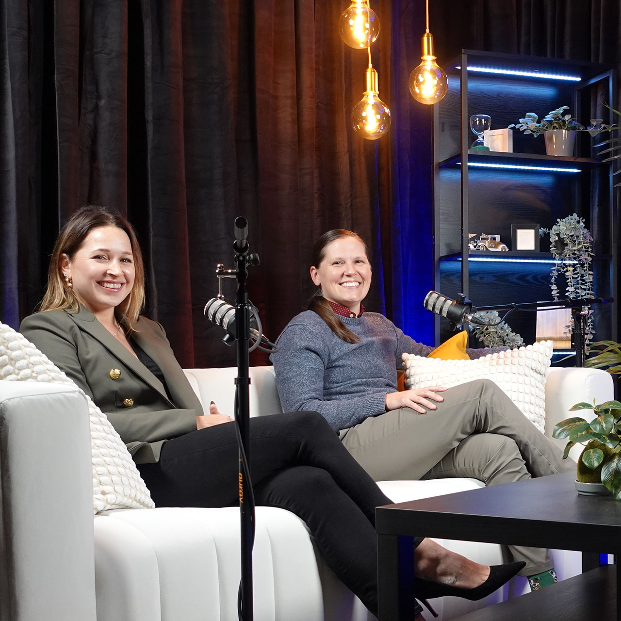 Three women sitting in a room with microphones