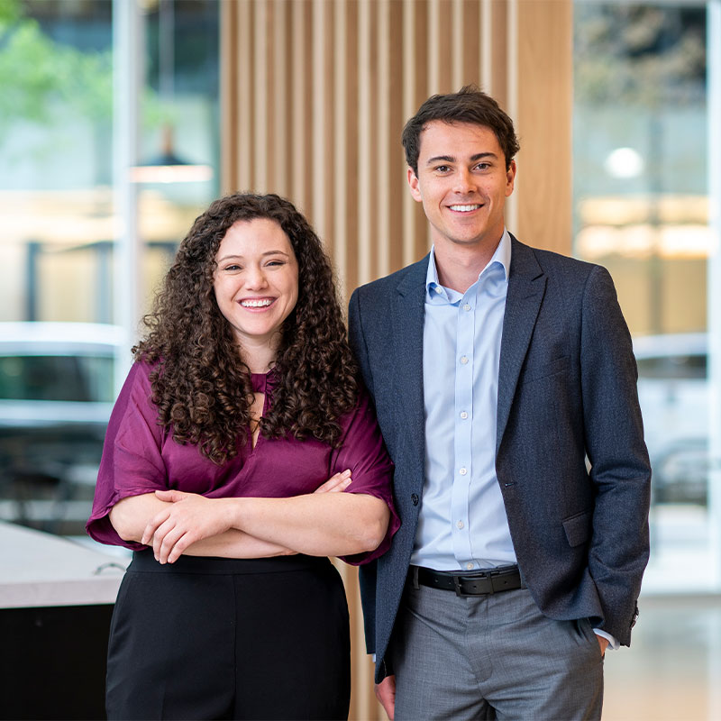 Two students smiling and standing.