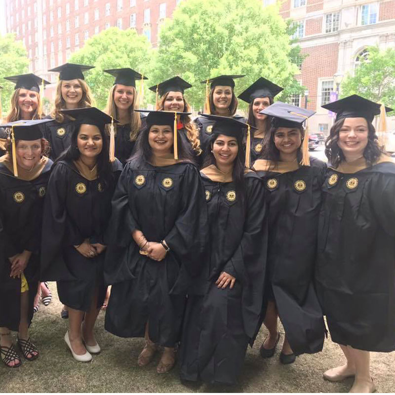 Rachel Wiseley stands with other Scheller MBA graduates in their cap and gown
