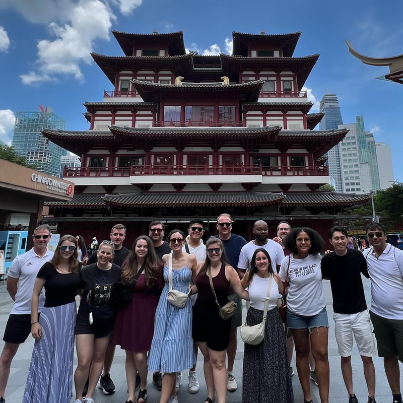 group of students posing in front of a building