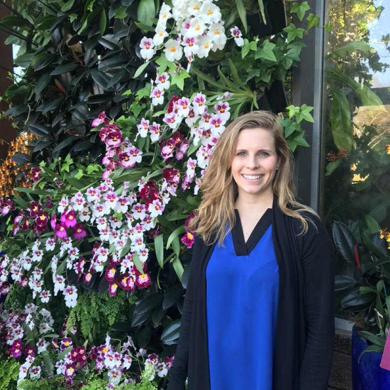 Ashleigh Bryan, Scheller Evening MBA ‘24, stands in front of a flowering tree