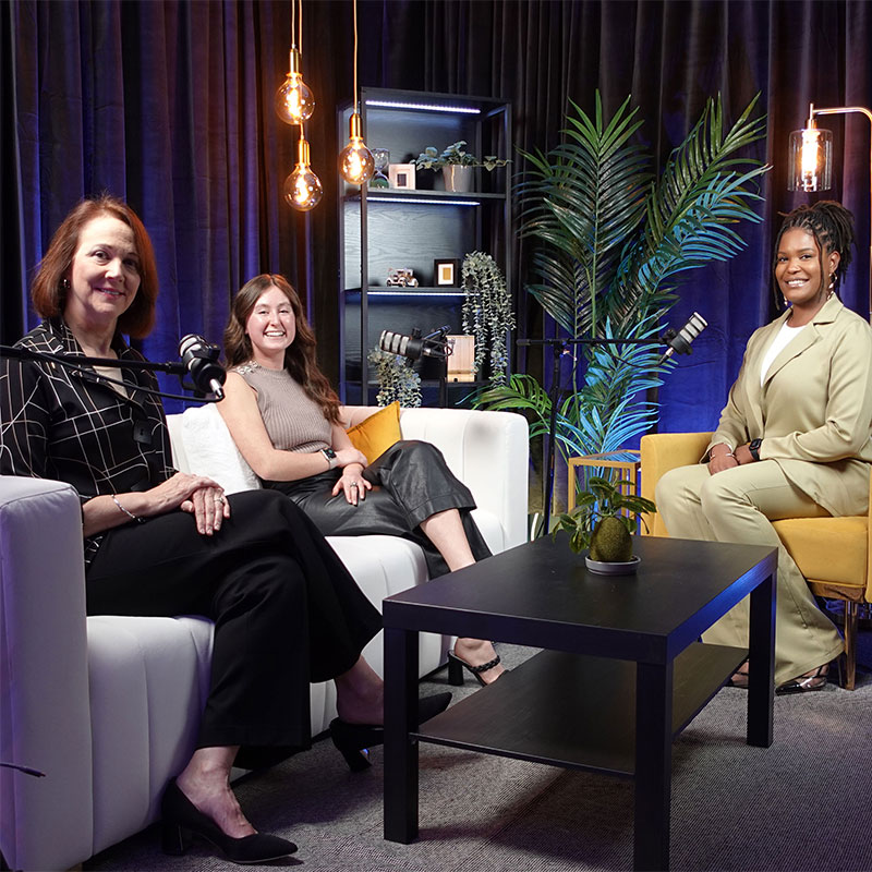 A group of women sitting at a table with microphones.