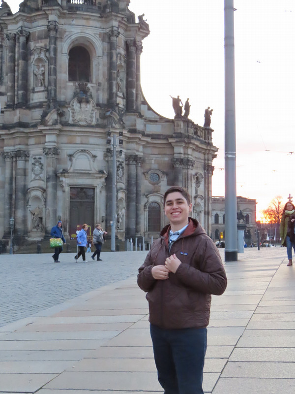 student posing next to building