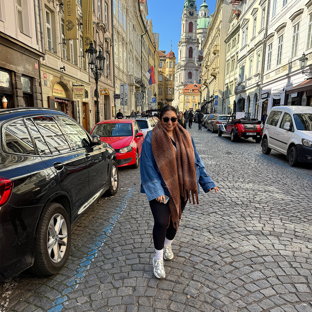 A happy young woman posing in a European street for travel